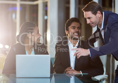 Businesswoman discussing with colleagues over laptop