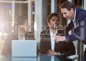 Businesswoman discussing with colleagues over laptop