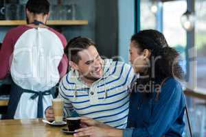 Smiling young couple having coffee in cafe