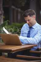 Handsome businessman using laptop and digital tablet