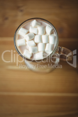 Cup of coffee with marshmallow on wooden table