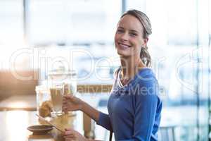 Smiling woman using digital tablet at counter in cafÃ?Â©