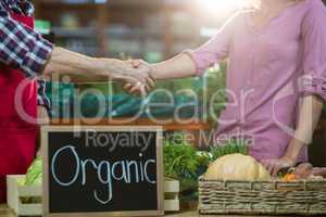 Staff shaking hand with woman in organic section