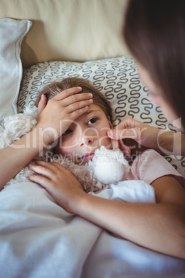 Mother checking daughters temperature