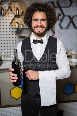 Bartender serving bottle of wine in bar counter