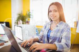 Happy female graphic designer working with laptop