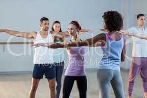 Yoga instructor helping student with a correct pose