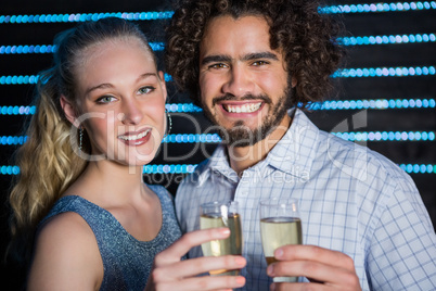 Couple holding glass of champagne in bar