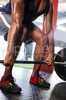 Male athlete lifting barbell in fitness studio