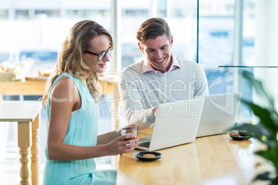 Man and woman using laptop during meeting