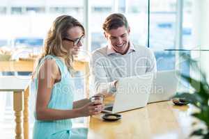 Man and woman using laptop during meeting
