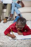 Boy doing homework while lying on the floor