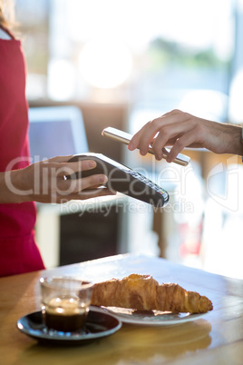 Man paying bill through smartphone using NFC technology