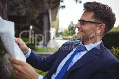 Handsome businessman reading newspaper