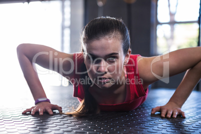 Portrait of sporty athlete doing push-ups in gym