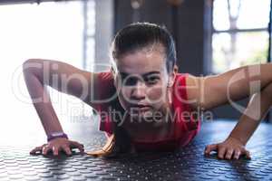 Portrait of sporty athlete doing push-ups in gym