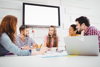 Happy colleagues discussing at creative office