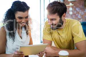Couple using a digital tablet in coffee shop