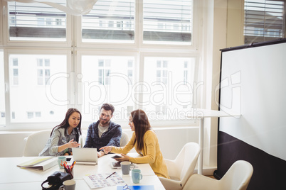 Photo editors using laptop in meeting room