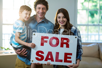 Couple standing and holding sold sign
