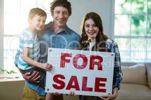 Couple standing and holding sold sign