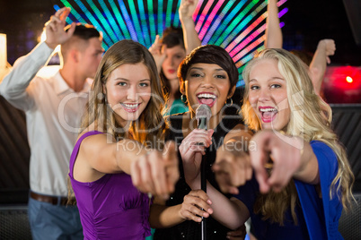 Female friends singing song together in bar