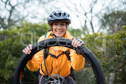 Portrait of female biker repairing mountain bike