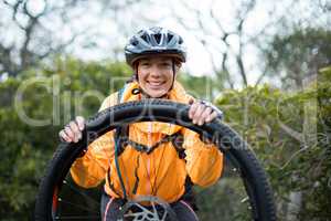Portrait of female biker repairing mountain bike