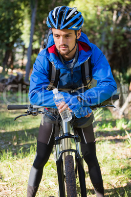 Male mountain biker standing with bicycle