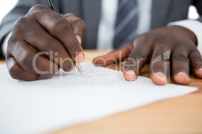 Hands of a man signing document