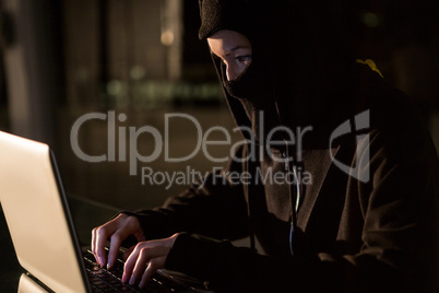 Woman in balaclava using laptop