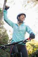 Excited female mountain biker in forest