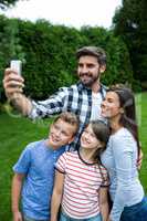 Happy family taking a selfie from mobile phone in park