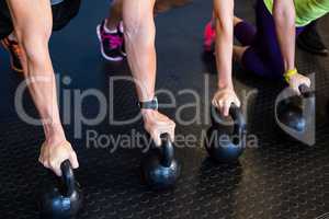 Athletes exercising with kettlebells in gym