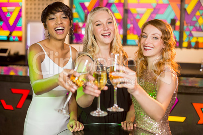 Three smiling friend toasting glass of champagne