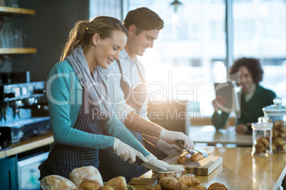 Waiter and waitress working at counter in cafÃ?Â©