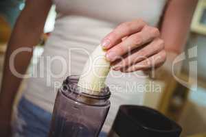 Woman preparing banana smoothie