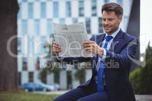 Handsome businessman reading newspaper