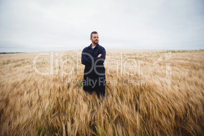 Farmer standing with arms crossed in the field