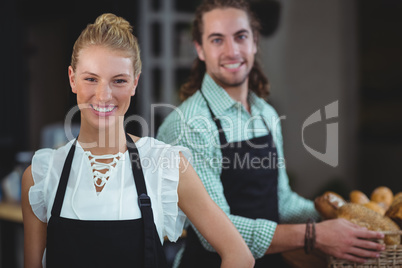 Portrait of waiter and waitress working behind the counter