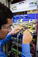 Technician checking cables in a rack mounted server