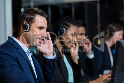 Colleagues with headsets using computer at office