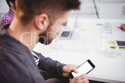 Executive using mobile phone in meeting at creative office