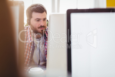 Confident executive working on computer at creative office