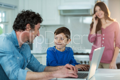 Father and son using laptop