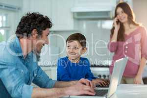 Father and son using laptop