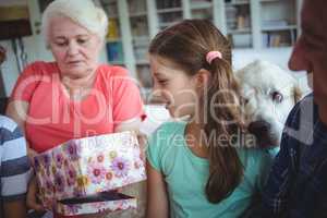 Grandparents and grandchildren looking at surprise gift in living room