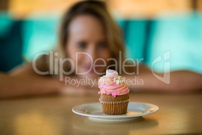 Woman looking at cupcake on plate