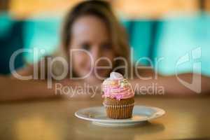 Woman looking at cupcake on plate