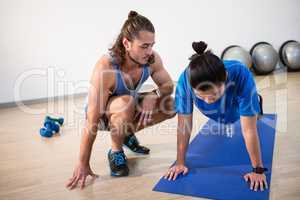 Fitness instructor helping fitness man with push-up